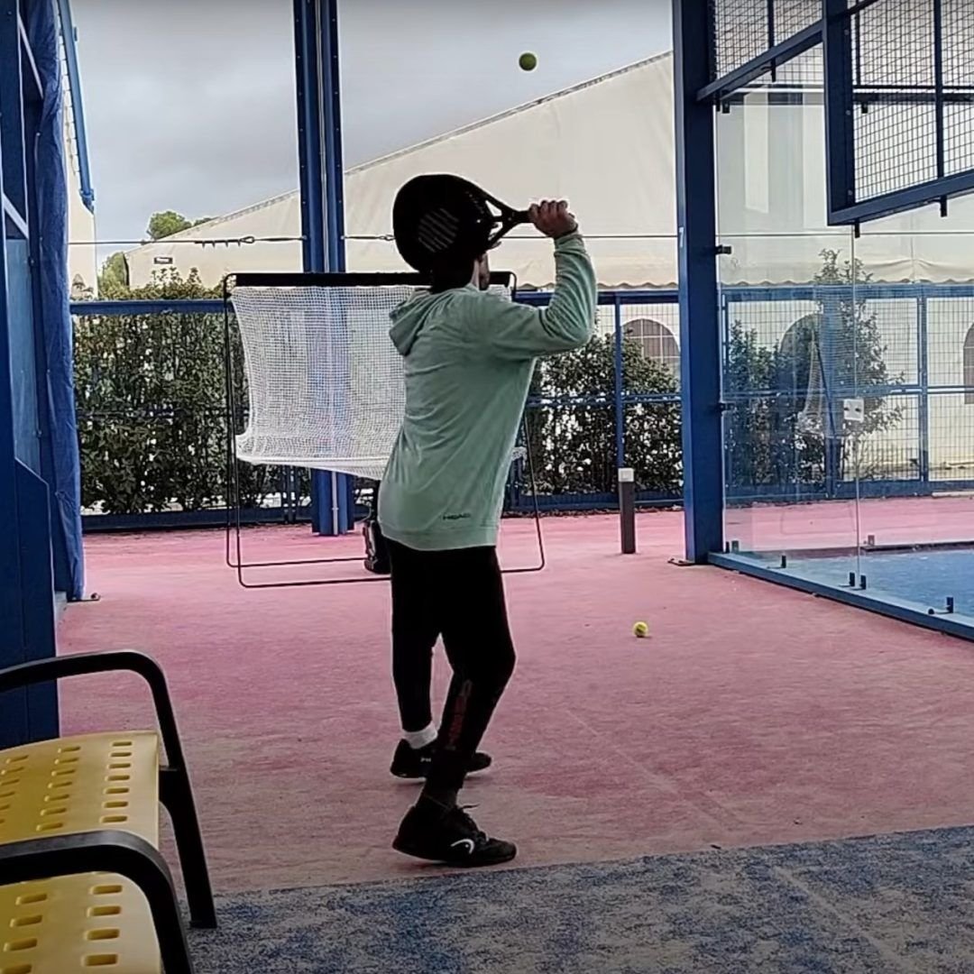 Jugador entrenando con la máquina lanzapelotas y la red de ciclo continuo Pro Padel GO