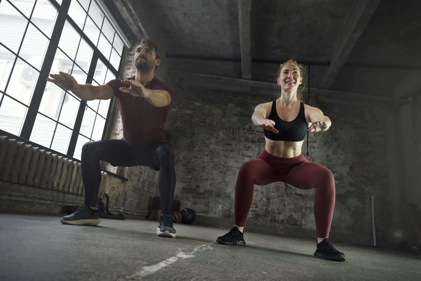 Dos personas entrenando piernas en un gimnasio