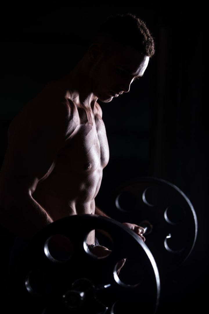 Joven muscular entrenando con barra